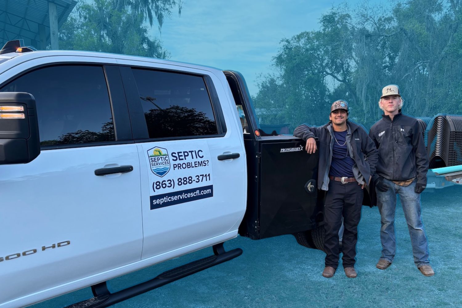 Two technicians standing beside a white service truck displaying the "Septic Services of Central Florida" logo, phone number, and website address.